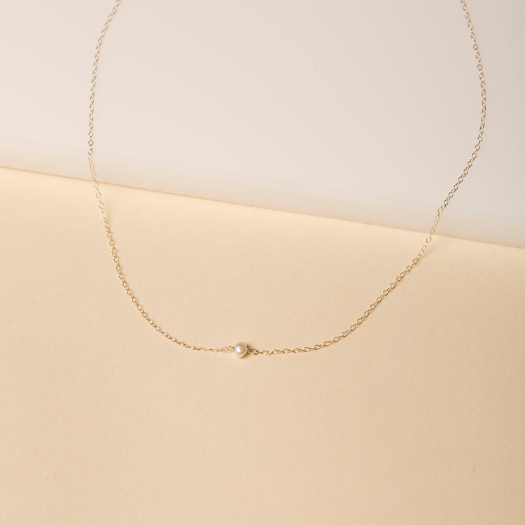 Stone and Strand 14K Yellow Gold Tiny Solitaire Pearl Necklace Editorial Image