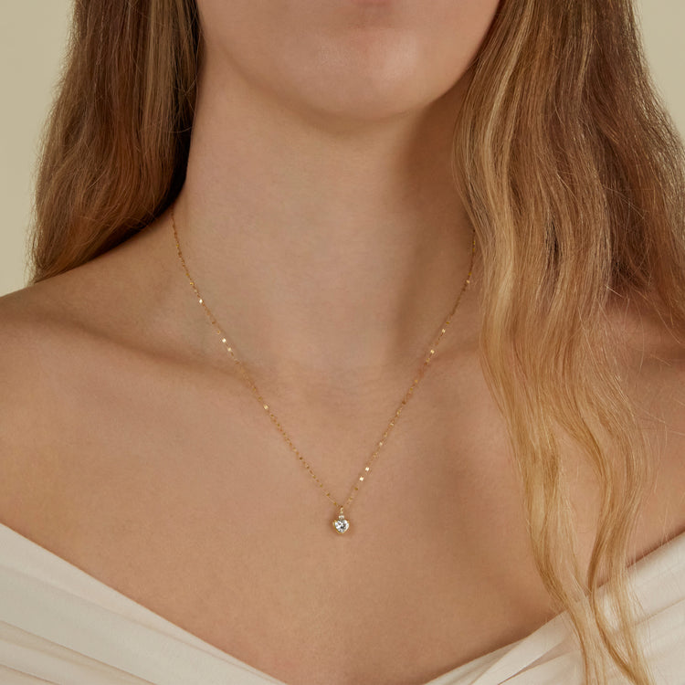 Image of 10K Yellow Gold Diamond Water Sign Heart Charm with Aquamarine on Models Neck