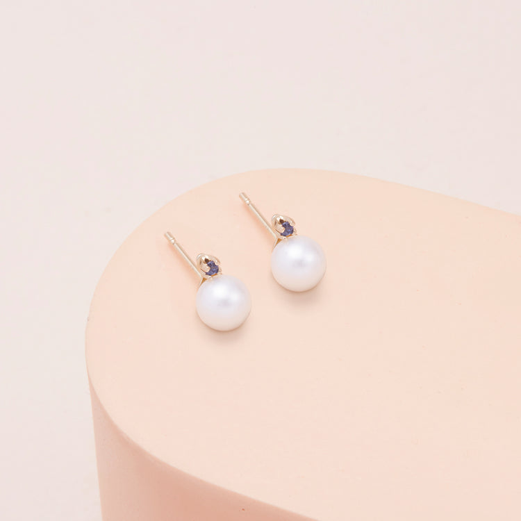 Stone and Strand 14K Yellow Gold Small Pearl and Sapphire Stud Earrings Editorial Image