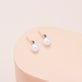 Stone and Strand 14K Yellow Gold Small Pearl and Sapphire Stud Earrings Editorial Image